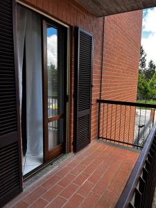 a balcony with a door and a brick building at nido delle farfalle in Stazione di Chiusi