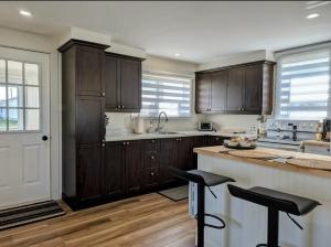 a kitchen with wooden cabinets and a counter top at Chez Thomas, la maison du pêcheur in Grande Anse