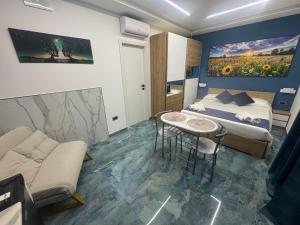 a bedroom with a bed and a table and a couch at Costa blu in Agropoli