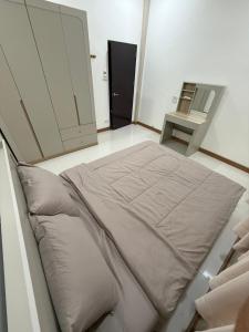 a large bed in a room with a mirror at Happy day in Nong Prue