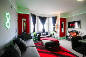 a living room with a couch and a red wall at Aura - 8ight Havens in Folkestone