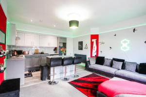 a living room with a couch and a kitchen at Aura - 8ight Havens in Folkestone