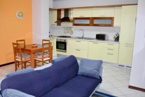 a living room with a blue couch and a kitchen at nido delle farfalle in Stazione di Chiusi