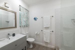 a white bathroom with a toilet and a shower at Southwinds - by ZenBreak in Saint Peter +9 photos