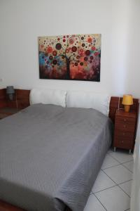 a bedroom with a bed and a painting on the wall at nido delle farfalle in Stazione di Chiusi