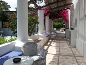 un patio con sillas, una mesa y flores en Casa Carlotta, en Stromboli