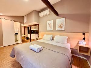a bedroom with a large white bed with towels on it at Injoy Suítes & Aparts in Rio de Janeiro