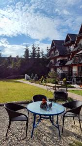 a table with two chairs and a table with a cake on it at ECO Willa Karpatia Ski&Wellness in Murzasichle