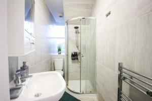 a bathroom with a shower and a sink and a toilet at Vibrant - 8ight Havens in Folkestone +111 photos