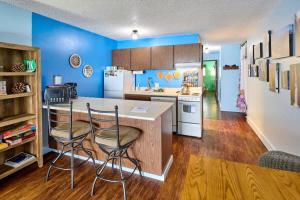 a kitchen with blue walls and a counter and two chairs at Lovely Oceanfront Condo -Top Floor - Pet Friendly in Lincoln City