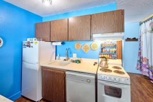 a kitchen with a white refrigerator and a sink at Lovely Oceanfront Condo -Top Floor - Pet Friendly in Lincoln City