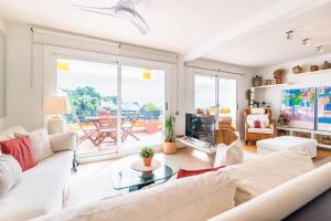a living room with a white couch and a table at Marvista - Bright Apt w Seaview, Pool in Sant Pere de Ribes