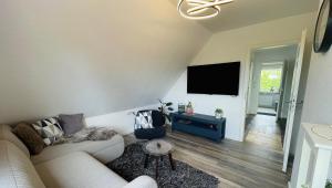 ein Wohnzimmer mit Sofa und Flachbildfernseher in der Unterkunft ElbZeit in Hitzacker