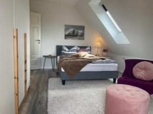 ein Schlafzimmer mit einem Bett und einem lila Stuhl in der Unterkunft ElbZeit in Hitzacker