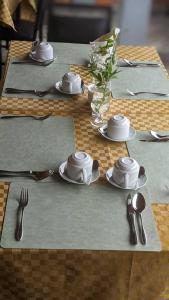 a table with plates and utensils on top at Mansarda Park View Hotel in Nyagatare