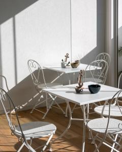 two white tables and chairs in a room at Vira Verso Est in Otranto