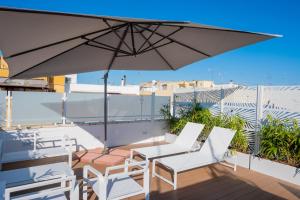 a patio with a table and chairs and an umbrella at Vira Verso Est in Otranto