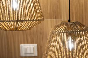 two lights hanging from a wall with a light switch at Vira Verso Est in Otranto