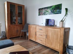 a living room with a wooden dresser and a cabinet at FEWO Geborgenheit ASZA mit strahlungsfreien Zonen in Bautzen