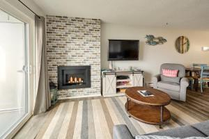 a living room with a fireplace and a couch at Oceanfront Condo - Second Floor - Pet Friendly in Lincoln City