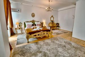 a bedroom with a king sized bed and a chandelier at Hotel Coroana Moldovei in Slănic-Moldova