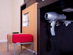 a blow dryer is attached to a door with a red stool at Novotel Southampton in Southampton