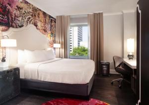 a hotel room with a bed and a desk and a window at Hotel Indigo Atlanta Midtown by IHG in Atlanta +47 photos