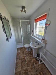 a bathroom with a sink and a toilet and a shower at Lochan View Cottage in Breaclete +18 photos