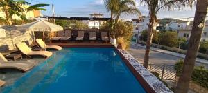 a swimming pool with lounge chairs and a resort at Villa Nefeli Ksamil in Ksamil