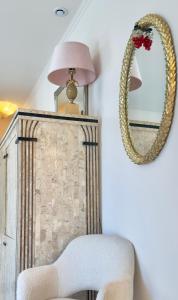 a mirror and a white chair in a room at Monaco 2bdr luxury apartment, private garden&pool in Beausoleil
