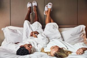 two people laying in bed with their feet in the air at The Clayfield, in the Unbound Collection by Hyatt in Niagara-on-the-Lake