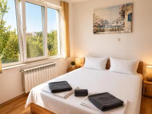 a bedroom with a white bed with two towels on it at Villa Avelia - Sea View Jacuzzi Retreat in Varna City +24 photos