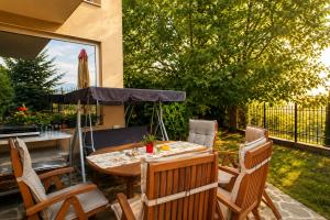 a patio with a table and chairs and an umbrella at Villa Avelia - Sea View Jacuzzi Retreat in Varna City