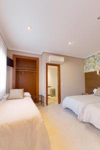 a bedroom with two beds and a window at Hostal Sol in Toledo