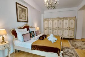 a bedroom with a bed and a chandelier at Hotel Coroana Moldovei in Slănic-Moldova +33 photos