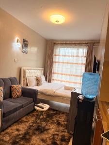 a small living room with a couch and a bed at HIDEOUT BnB with swimming pool in Kiambu