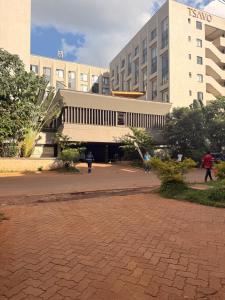 a person flying a kite in front of a building at HIDEOUT BnB with swimming pool in Kiambu