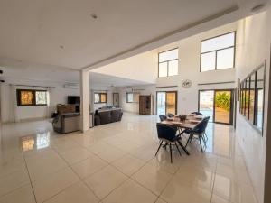 a large living room with a table and chairs at Villa Lawsmat avec piscine privée et grand jardin in Lomé