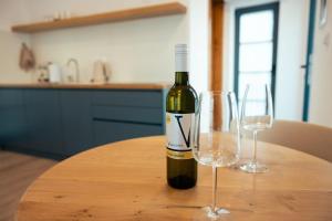 a bottle of wine sitting on a table with two wine glasses at Villa Eva in Ajdovščina +20 photos