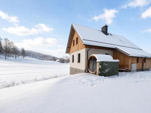 a barn in the snow with a snow covered field at Chalupa pod Špičákem in Smržovka