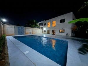 a swimming pool in front of a building at night at Villa Lawsmat avec piscine privée et grand jardin in Lomé