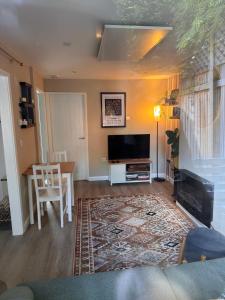 a living room with a flat screen tv and a table at The Lazy Fox, Shrewsbury in Shrewsbury