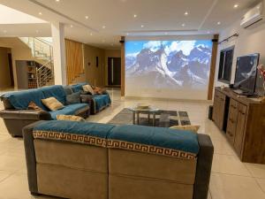 a large screen in a living room with a couch at Villa Lawsmat avec piscine privée et grand jardin in Lomé