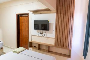 a room with a tv on a wall at New Apart Hotel Ciudad del Este in Ciudad del Este