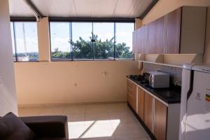 a kitchen with a counter and a large window at New Apart Hotel Ciudad del Este in Ciudad del Este