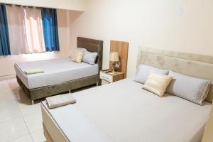 a bedroom with two beds and a window at New Apart Hotel Ciudad del Este in Ciudad del Este +24 photos
