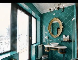 a blue bathroom with a sink and a mirror at Hotel Coroana Moldovei in Slănic-Moldova