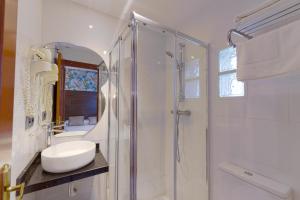 a white bathroom with a sink and a shower at Hostal Sol in Toledo