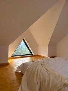 a bed in a room with a large window at Dor de Munte in Vărtăneşti