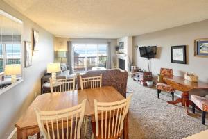 a living room with a table and a couch at Ground Floor - Ocean View Condo - Pet-Friendly in Lincoln City